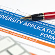 Pen resting on top of a blank paper college application form.