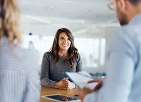 Young female candidate talking to human resource team during a job interview in the office.