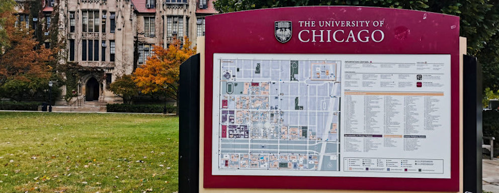 A campus map sign next to a walkway on the University of Chicago quad.